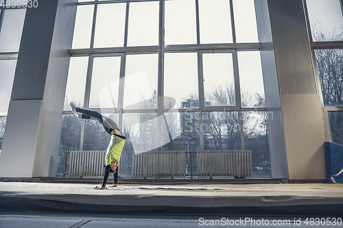 Image of Little male gymnast training in gym, flexible and active