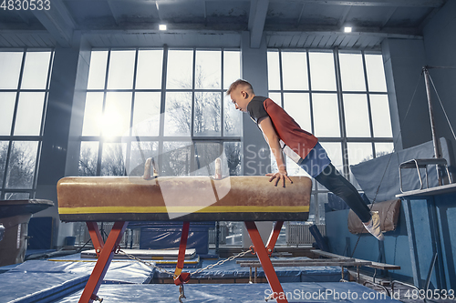 Image of Little male gymnast training in gym, flexible and active