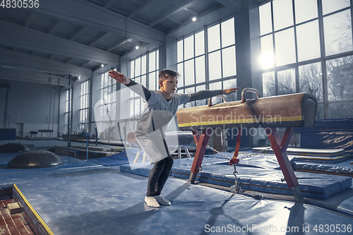 Image of Little male gymnast training in gym, flexible and active