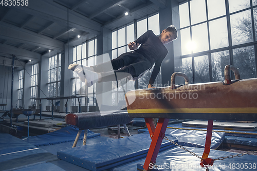 Image of Little male gymnast training in gym, flexible and active