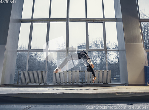 Image of Little male gymnast training in gym, flexible and active