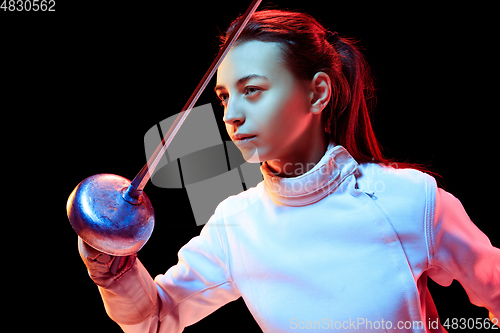 Image of Teen girl in fencing costume with sword in hand isolated on black background