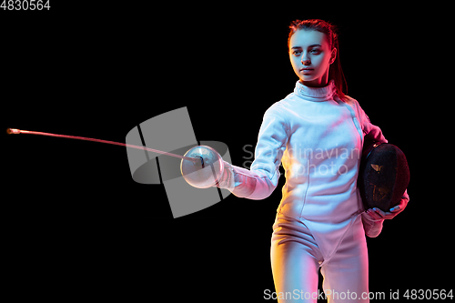 Image of Teen girl in fencing costume with sword in hand isolated on black background