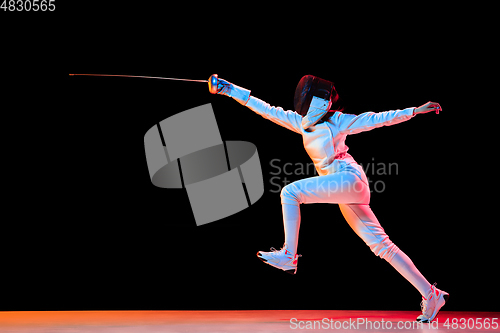 Image of Teen girl in fencing costume with sword in hand isolated on black background