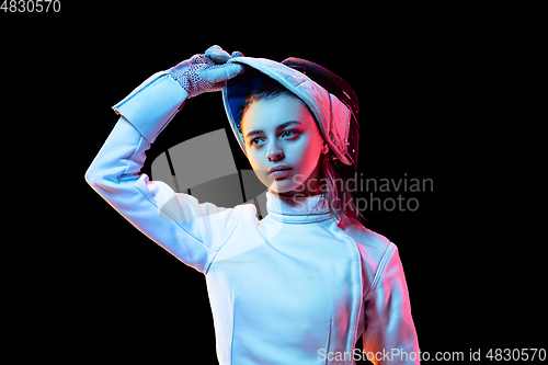 Image of Teen girl in fencing costume with sword in hand isolated on black background