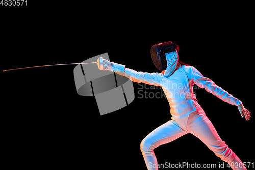 Image of Teen girl in fencing costume with sword in hand isolated on black background