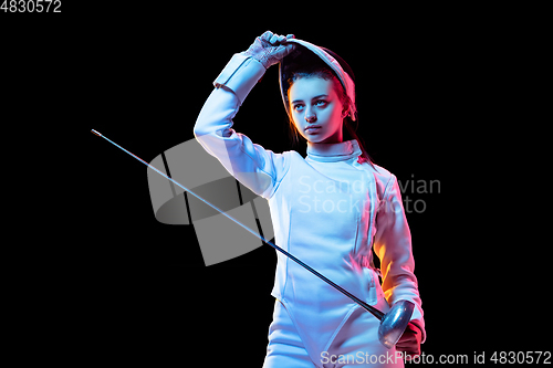 Image of Teen girl in fencing costume with sword in hand isolated on black background
