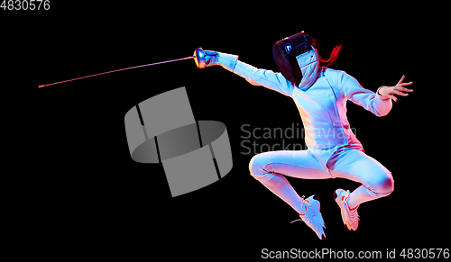 Image of Teen girl in fencing costume with sword in hand isolated on black background