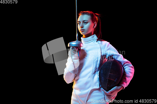 Image of Teen girl in fencing costume with sword in hand isolated on black background