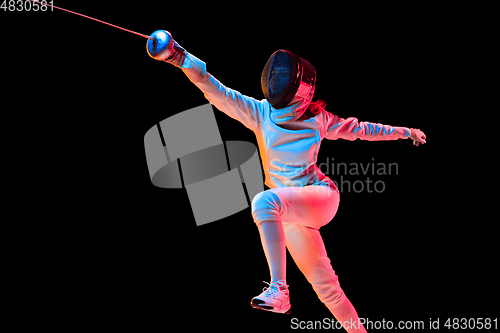 Image of Teen girl in fencing costume with sword in hand isolated on black background