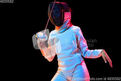 Image of Teen girl in fencing costume with sword in hand isolated on black background