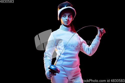 Image of Teen girl in fencing costume with sword in hand isolated on black background