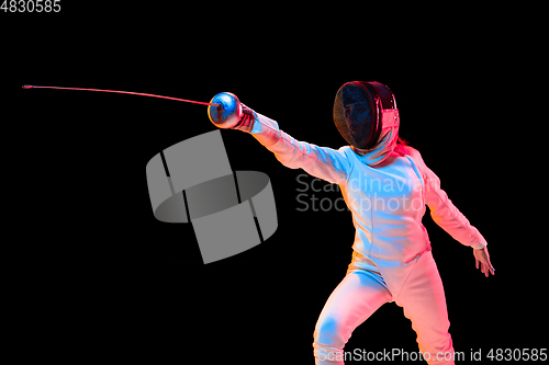 Image of Teen girl in fencing costume with sword in hand isolated on black background