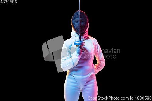 Image of Teen girl in fencing costume with sword in hand isolated on black background