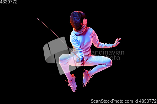 Image of Teen girl in fencing costume with sword in hand isolated on black background