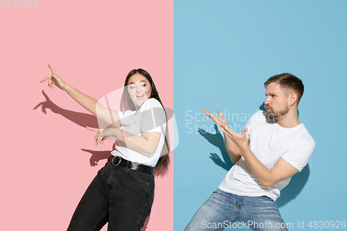 Image of Young emotional man and woman on pink and blue background