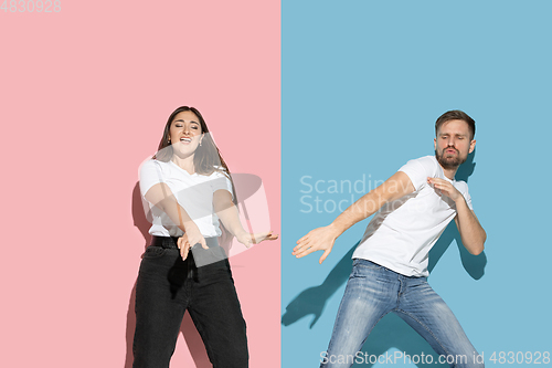 Image of Young emotional man and woman on pink and blue background