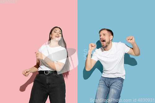 Image of Young emotional man and woman on pink and blue background