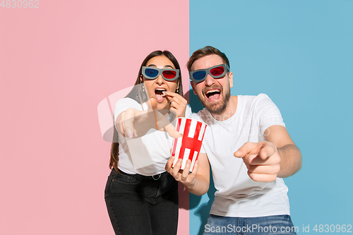 Image of Young emotional man and woman on pink and blue background