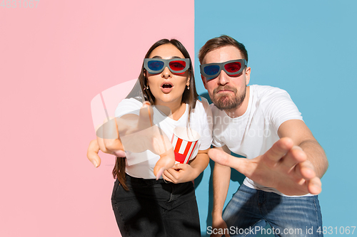 Image of Young emotional man and woman on pink and blue background