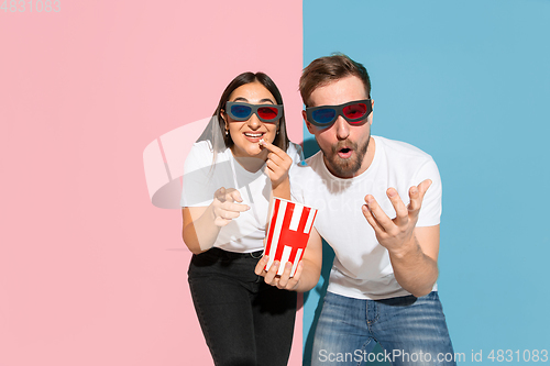 Image of Young emotional man and woman on pink and blue background