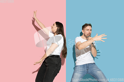 Image of Young emotional man and woman on pink and blue background