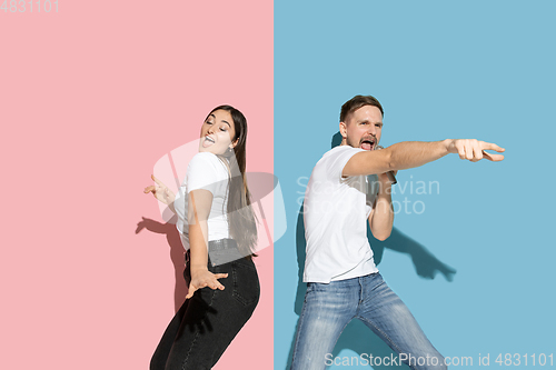 Image of Young emotional man and woman on pink and blue background