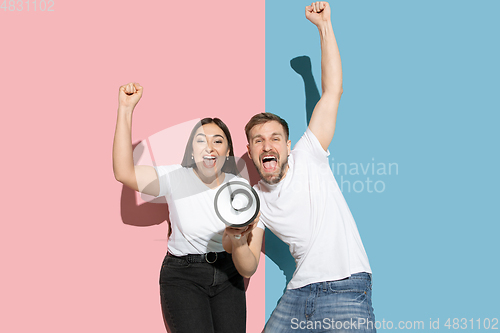 Image of Young emotional man and woman on pink and blue background