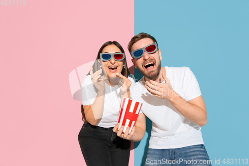 Image of Young emotional man and woman on pink and blue background