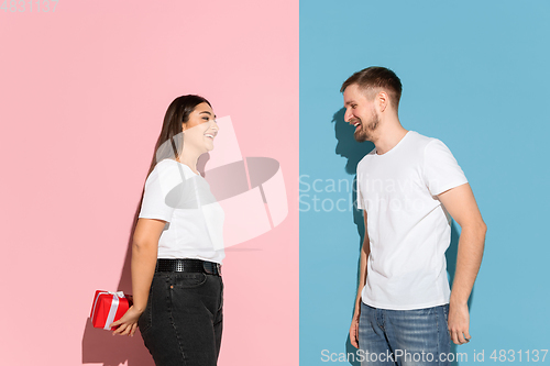 Image of Young emotional man and woman on pink and blue background