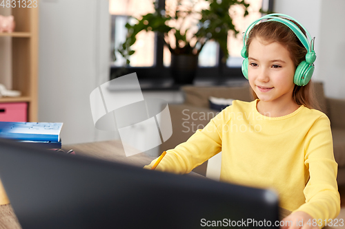 Image of girl in headphones with laptop computer at home