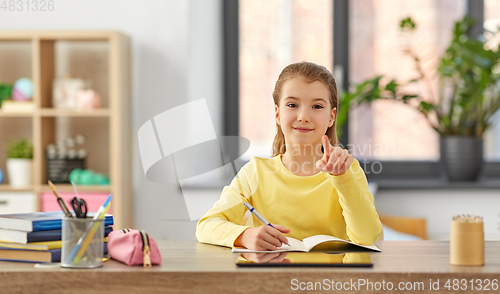 Image of student girl pointing finger to camera at home