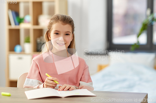 Image of girl with notebook and marker drawing at home
