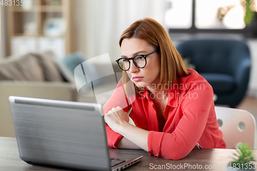 Image of bored woman with laptop working at home office