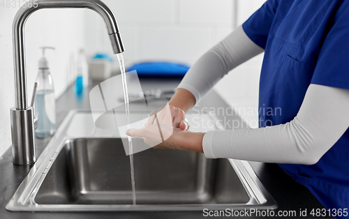 Image of doctor or nurse washing hands with liquid soap