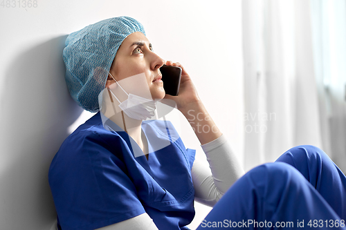 Image of sad doctor or nurse calling on smartphone