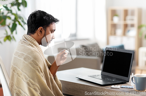 Image of sick man thermometer having video call on laptop