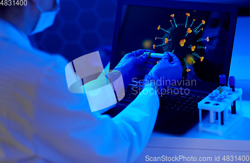 Image of hand holding beaker with coronavirus blood test