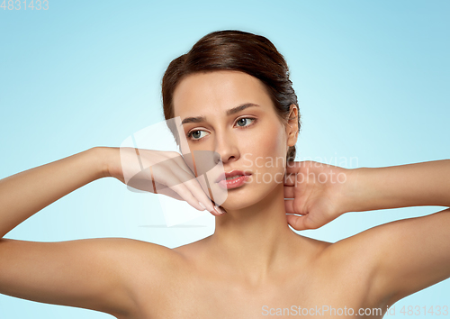 Image of beautiful young woman touching her face