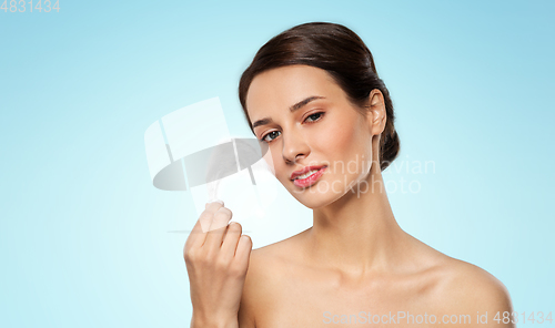 Image of beautiful woman with feather touching her face