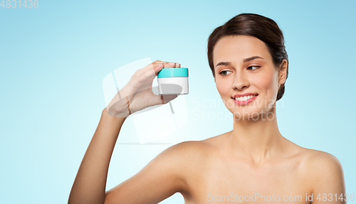 Image of happy young woman holding jar of cream