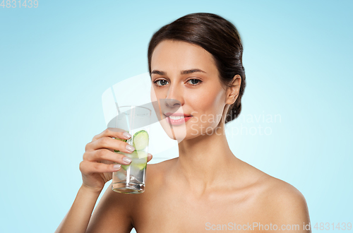 Image of woman drinking water with cucumber and ice