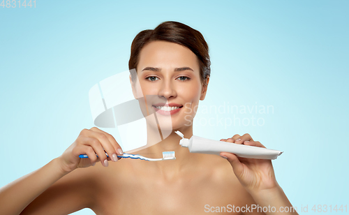 Image of smiling woman with toothbrush cleaning teeth