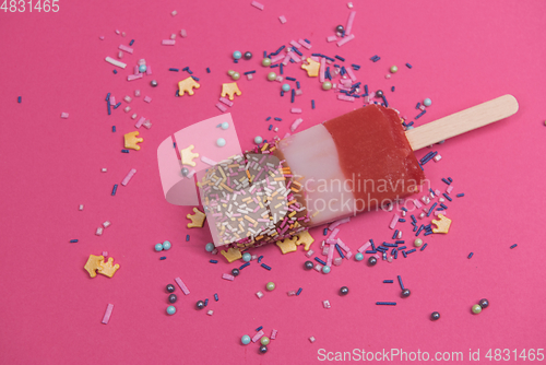 Image of Ice cream on stick with colorful sprinkles