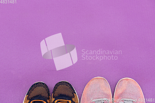 Image of Sneakers and a purple fitness mat. Sport concept