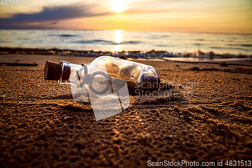 Image of Message in the bottle against the Sun setting down