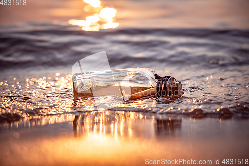 Image of Message in the bottle against the Sun setting down