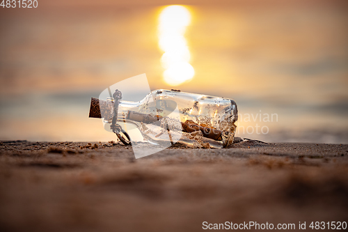 Image of Message in the bottle against the Sun setting down