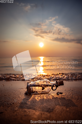 Image of Message in the bottle against the Sun setting down