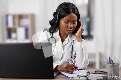 Image of doctor with headset and clipboard at hospital